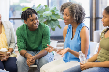 A group of women sitting and speaking together.