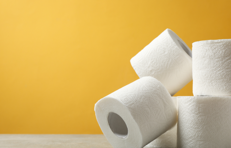 Four rolls of toilet paper stacked against a yellow background.